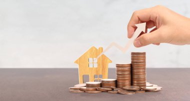 Tahta oyuncak ev ipoteği ev konsepti. Eldeki bozuk paralar B