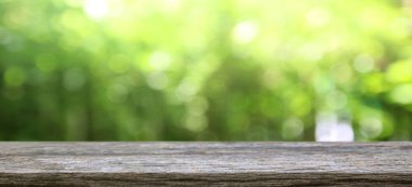 Doğa arka planı, ahşap masa, bulanık yeşil bahçe.