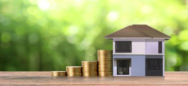 Bozuk para yığınlarının üzerinde duran küçük evler. Yatırım tasarruf dolandırıcılığı