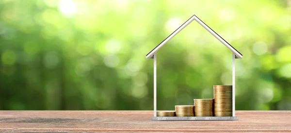 Malé domky stojící na hromadách mincí. ikona úspory investic — Stock fotografie