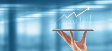 İşadamı, elinde tabletle iş yerinde grafik büyümesi ve grafik artışı planlıyor