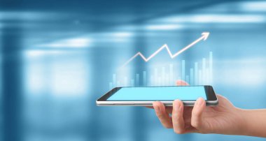 İşadamı, elinde tabletle iş yerinde grafik büyümesi ve grafik artışı planlıyor