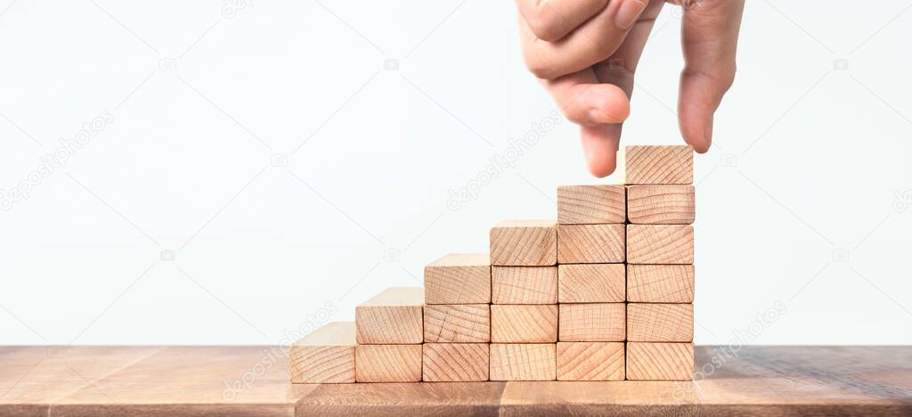 Hand liken person stepping up a toy staircase wood