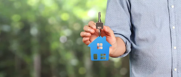 Real estate agent handing over house keys in a hand