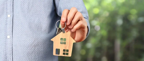 Real estate agent handing over house keys in a hand