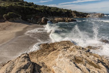 Dalgalar Corsica'deki / daki Calvi yakınındaki küçük bir kumlu koy üzerine crash