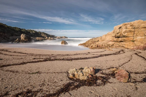 Vågorna tvätta på en liten vik med sandstrand nära Calvi på Korsika — Stockfoto