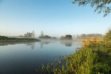 Güneş doğarken nehir Nene Northamptonshire'deki / daki üzerinde asılı sis