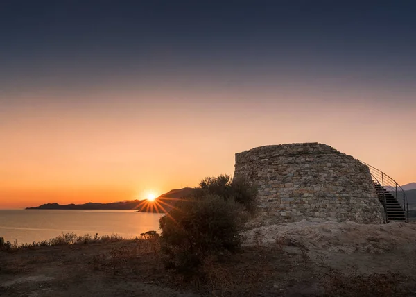 Sol nascendo atrás da torre genovesa em Lozari, na Córsega — Fotografia de Stock