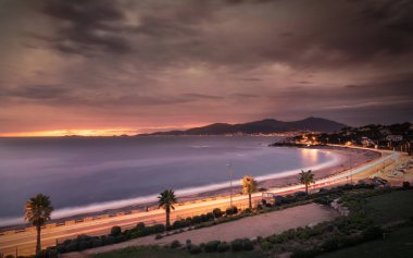 Günbatımı ve fırtınalı bulutlar Corsica'deki / daki Porticcio beach üzerinde