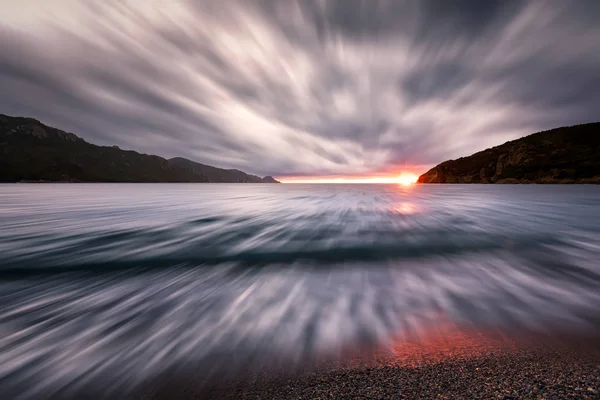 Pôr do sol sob nuvens de tempestade na praia de Bussaglia, na Córsega — Fotografia de Stock