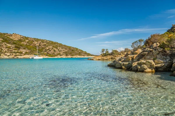 Zeilboot ligt afgemeerd in de baai, met rotsachtige rots in Corsica — Stockfoto