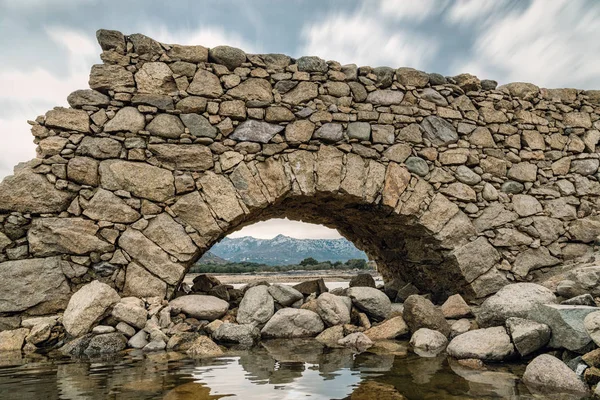 Vista de la montaña a través del abandonado arco de puente de piedra en Córcega — Foto de Stock