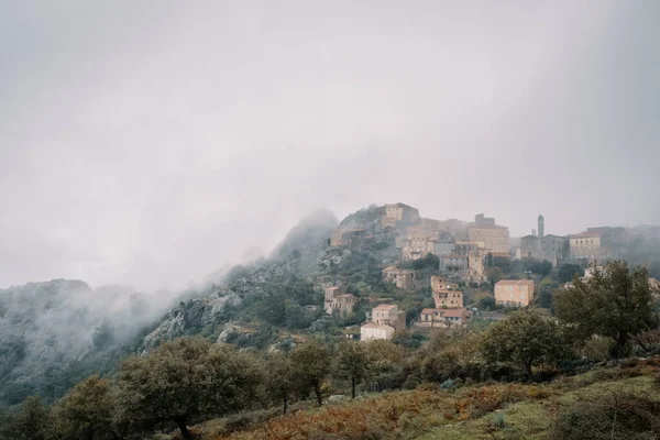 Vesnice Speloncato na Korsice zahalená v mlze — Stock fotografie