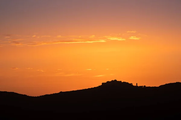 コルシカ島のBalagne地域にあるSant Antoninoのシルエットの古代の山間の村の後ろの日没のオレンジと紫色のアフターグロー — ストック写真