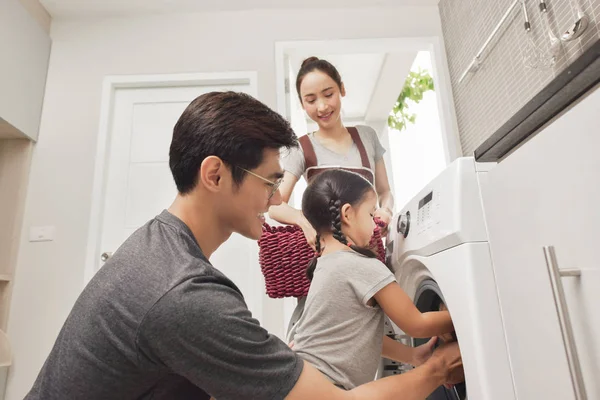 Happy Family loading clothes into washing machine — Stock Photo, Image