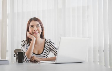 Güzel genç Freelancer kadın kullanarak dizüstü bilgisayar oturan, ev