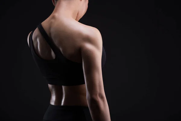 Athletische junge Frau zeigt Rückenmuskeln — Stockfoto