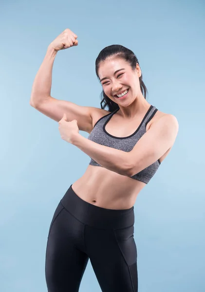 Joyeusement souriant asiatique sportif femme démontrant biceps — Photo