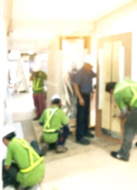 Bulanık arkaplanda mühendis olan inşaat işçileri.