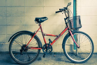 Evin dış duvarına karşı eski kırmızı bir bisiklet. Eski moda bir konsept..