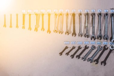 Eski duvarda asılı gerçek kullanılmış paslanmaz lambalar ya da İngiliz anahtarı seti..