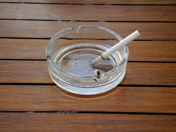 Ashtray on a table with a cigarette — Stock Photo, Image
