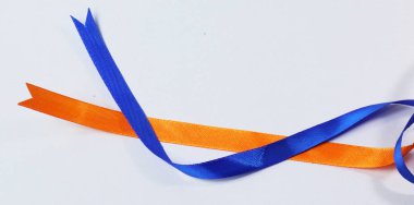 Turuncu ve mavi kurdele beyaz arkaplanda izole edilmiş.