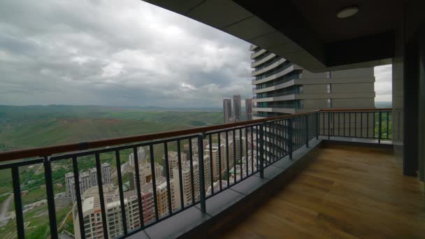 Cinematic 8K 7680x4320 60p. Balcony with very high view. Curved skyscraper terrace. Contemporary living at modern urban concept. Enclosed with a balustrade above the ground floor. City apartment house wide angle lens. — Stock Footage Cinematic 7680X4320 60P Balcony Very High View Curved Skyscraper Terrace Stock Video