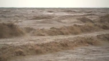 Kahverengi çamurlu deniz dalgaları. Sel suları denize ulaşır. Nehrin ağzında güçlü bir dalga oluşturur. Çamur yağmurdan sonra denize doğru ilerliyor. İnanılmaz hızlı akan azgın bir nehir okyanusu..