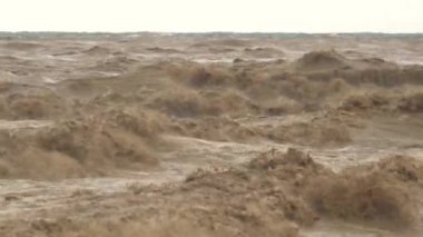 Kahverengi çamurlu deniz dalgaları. Sel suları denize ulaşır. Nehrin ağzında güçlü bir dalga oluşturur. Çamur yağmurdan sonra denize doğru ilerliyor. İnanılmaz hızlı akan azgın bir nehir okyanusu..
