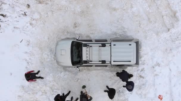 車は雪の中で立ち往生している 雪の中に車が立ち往生 助けようとしてる前方に戻る ブレーキとロッキングとトラクション 後ろからSuvを押してください 山道は閉鎖された 頭上の航空機の方法冷凍ハード強いパワーロックロック4Kロック — ストック動画
