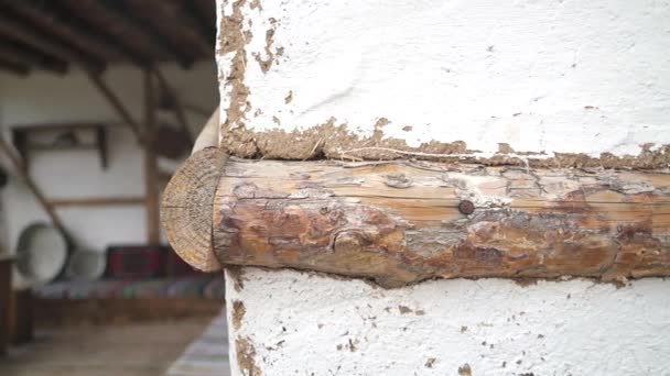 Wood backed adobe wall. Lime painted white wall. Balcony of a old village house. Wooden ceiling made of long wood. There is a long sofa and couch on the balcony. Old antique furnishings hanged on wall. Pan UHD 3840x2160. — Stock Footage Wood Backed Adobe Wall Lime Painted White Wall Balcony Old Video Clip