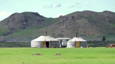 Gerçek göçebe dürbünle başka tarafa bakıyor. Orta Asya bozkırlarında yurtlar. Moğolistan 'da iki beyaz gri renkli çadır. Geleneksel yurt ger portatif çadır Göçebe bozkırlarını Asya 'da hissetti. Gers.