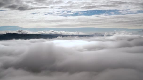 7680X4320地上の地形上の霧山の頂上からの雲の上の雲の上の雲の上の雲の上の雲の上の雲の上の雲の上の雲の上の雲の上の雲の上の層から霧の海が形成されています — ストック動画