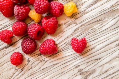 Masanın üstüne dağılmış ahududu böğürtlenleri. sarı ve kırmızı ahududu