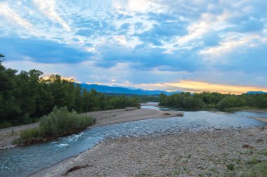 Nehir ve ormanlı güzel bir manzara.