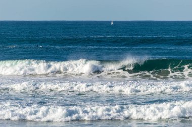 San Sebastian 'ın Zurriola plajında sörf tahtasıyla dalgaların üzerinde kayıyordu.