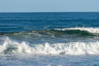 San Sebastian 'ın Zurriola plajında sörf tahtasıyla dalgaların üzerinde kayıyordu.