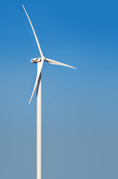 wind turbine isolated against blue sky with slight rotation