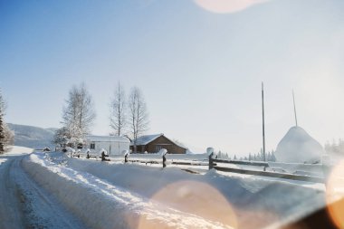 Evleri ve ağaçları olan kış manzarası yolu