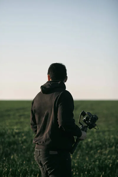Mladý Muž Video Operátor Stojící Zeleném Poli Stabilizačním Gimbalem Fotoaparátem — Stock fotografie