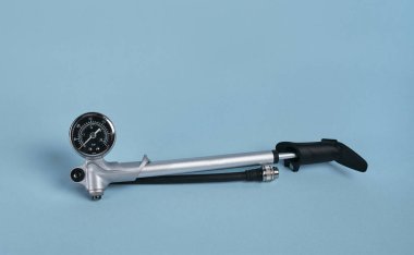 Mavi zemin üzerinde manometre izole edilmiş hava şoku ve çatallar için el yapımı yüksek basınçlı hava pompası.