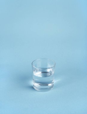Mavi arkaplanda izole edilmiş bir bardak su