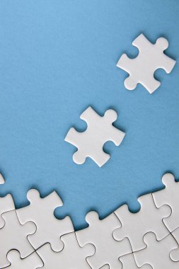 Mavi arkaplanda beyaz yapboz parçaları