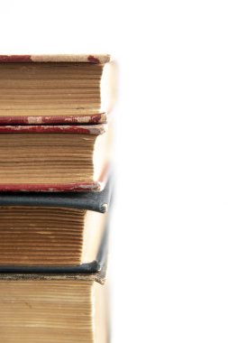 Beyaz yüzeye istiflenmiş eski kitaplar kopya alanı ile yakınlaşır