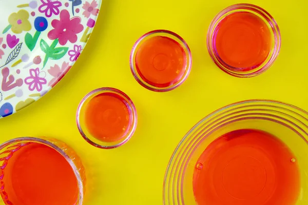 Cam kaselerde kırmızı meyve suyu ve yel üzerinde parlak renkli tabaklar. — Stok fotoğraf