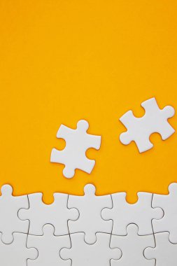 Beyaz yapboz parçaları turuncu arka planda negatif sp ile