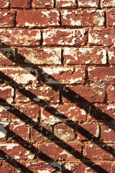 Mur de briques altérées et ombres diagonales — Photo