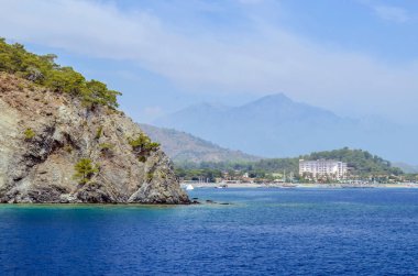 Resort. Akdeniz'in masmavi bir deniz. Güzel etkileyici bir doğa geçmiş. Büyük kayalar.
